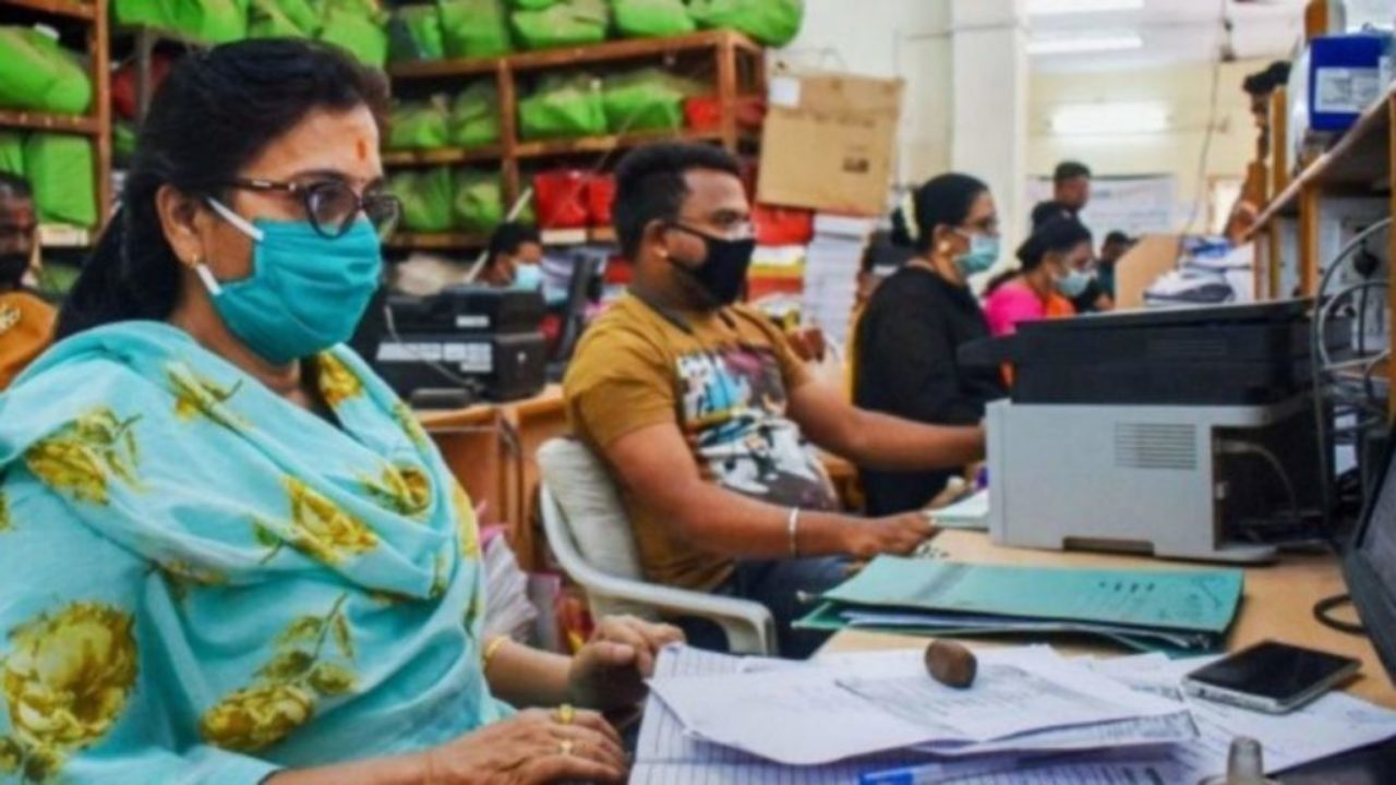 Employees practice social distancing and wear masks in office