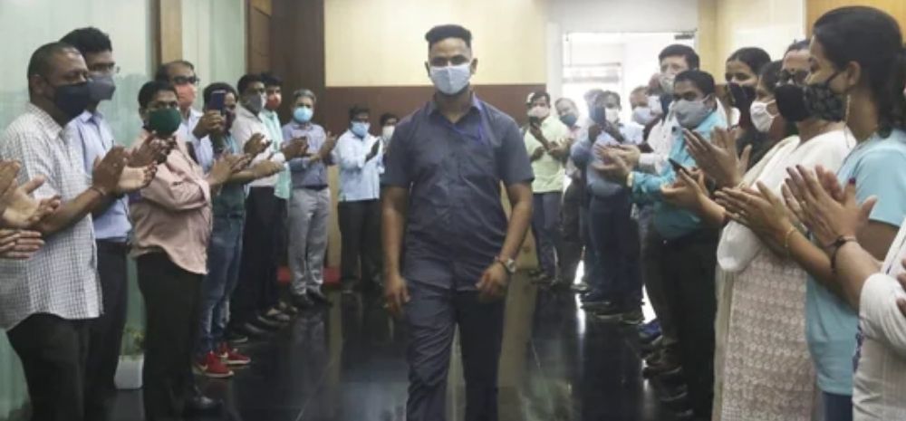 Mayur Shelke is flanked by railway staff who are applauding him for his courageous act