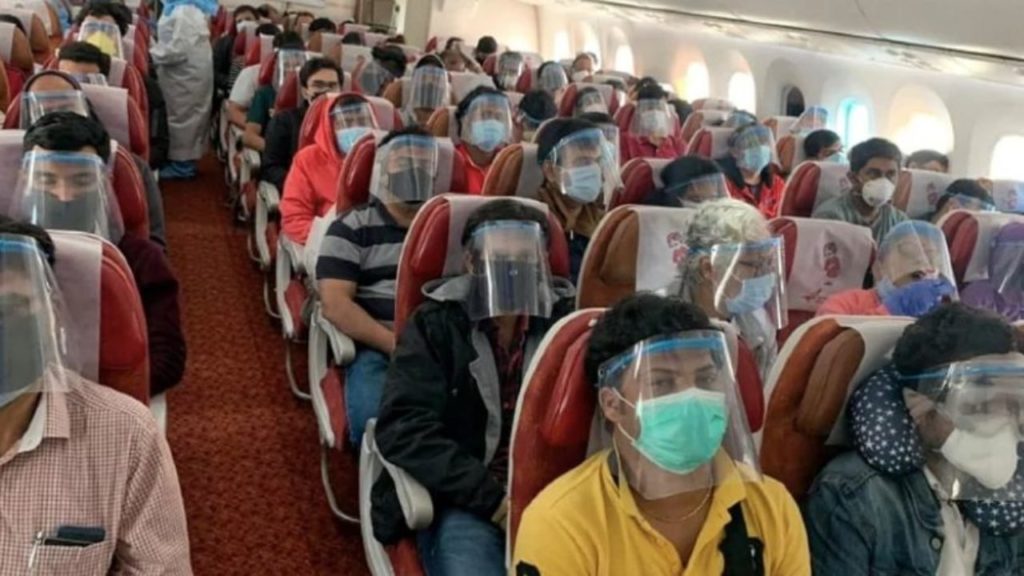 Passengers wearing masks and face shields seated on an airplane