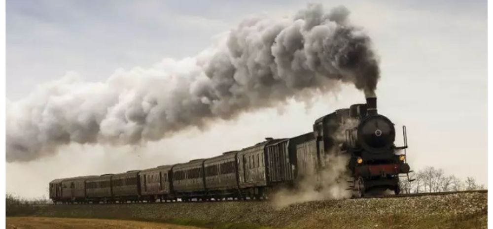 Image of a running locomotive with smoke coming out of its chimney