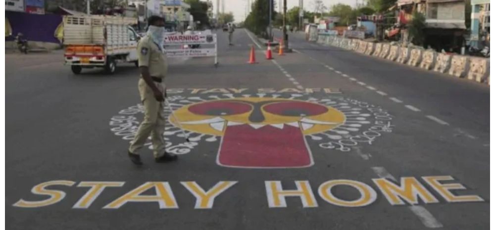 Police patrol empty streets with "STAY HOME" drawn on roads