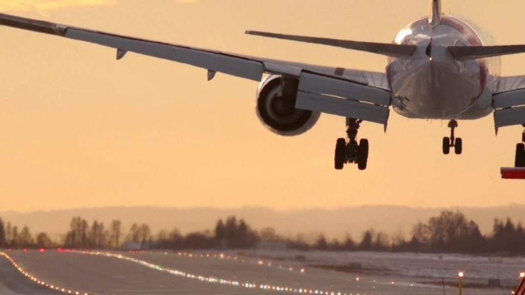 A plane hovering a few feet above runway tarmac