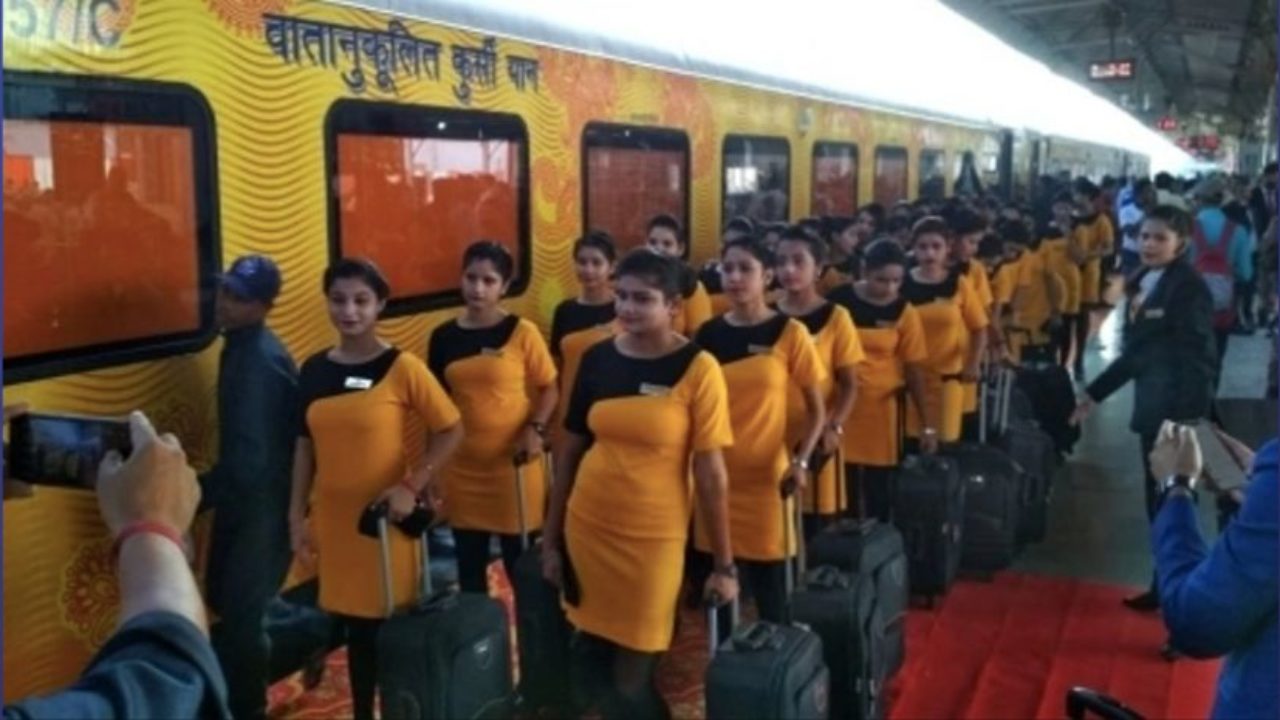 Chair car train attendants pose outside the parked train