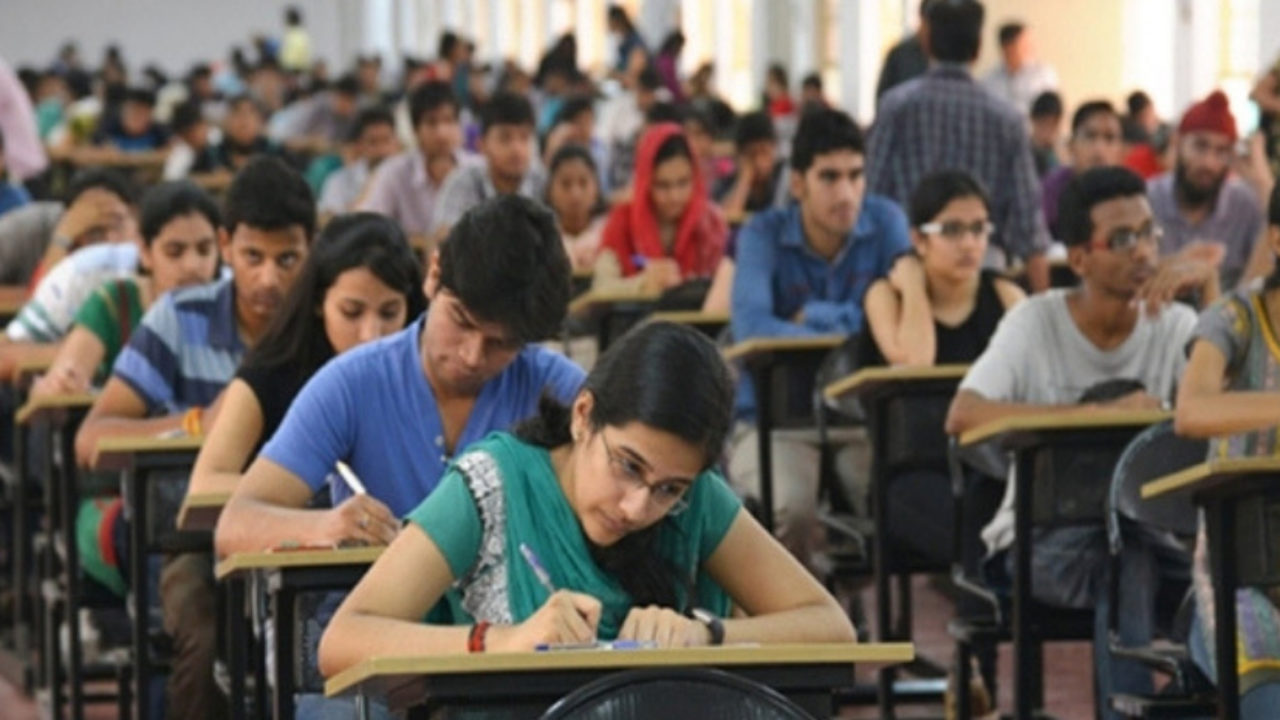 Students in a classroom writing an exam