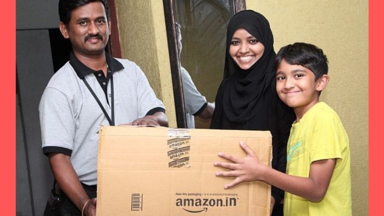 A woman and a child receiving an Amazon package from a delivery executive