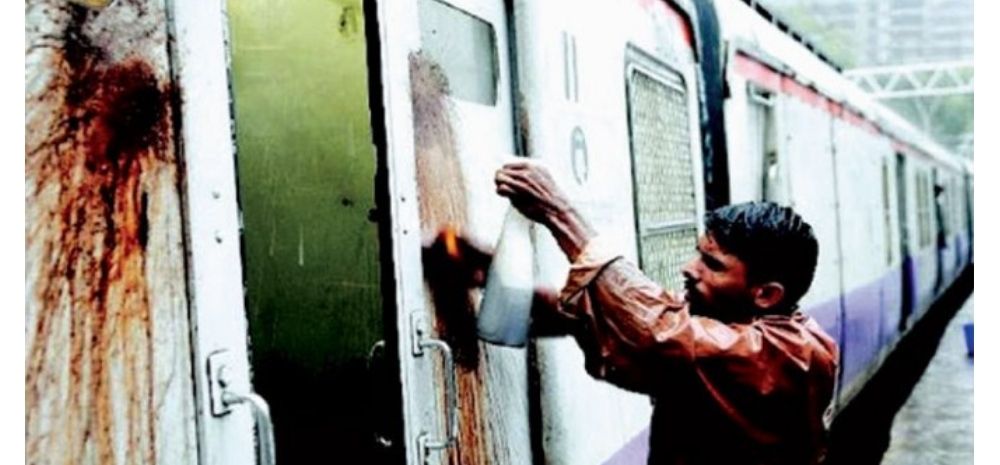 A worker cleaning tobacco spit stains on a train door