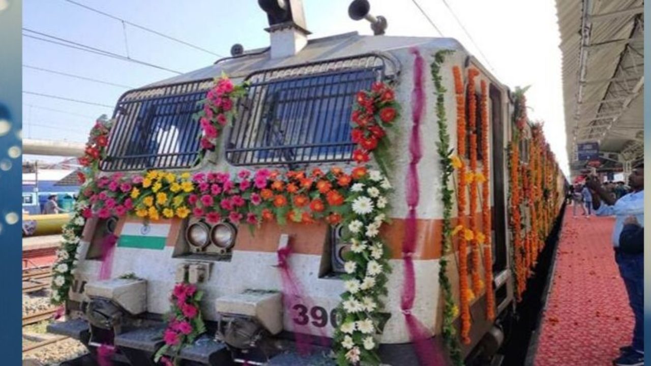 A train decorated with garlands and paint stops at a station