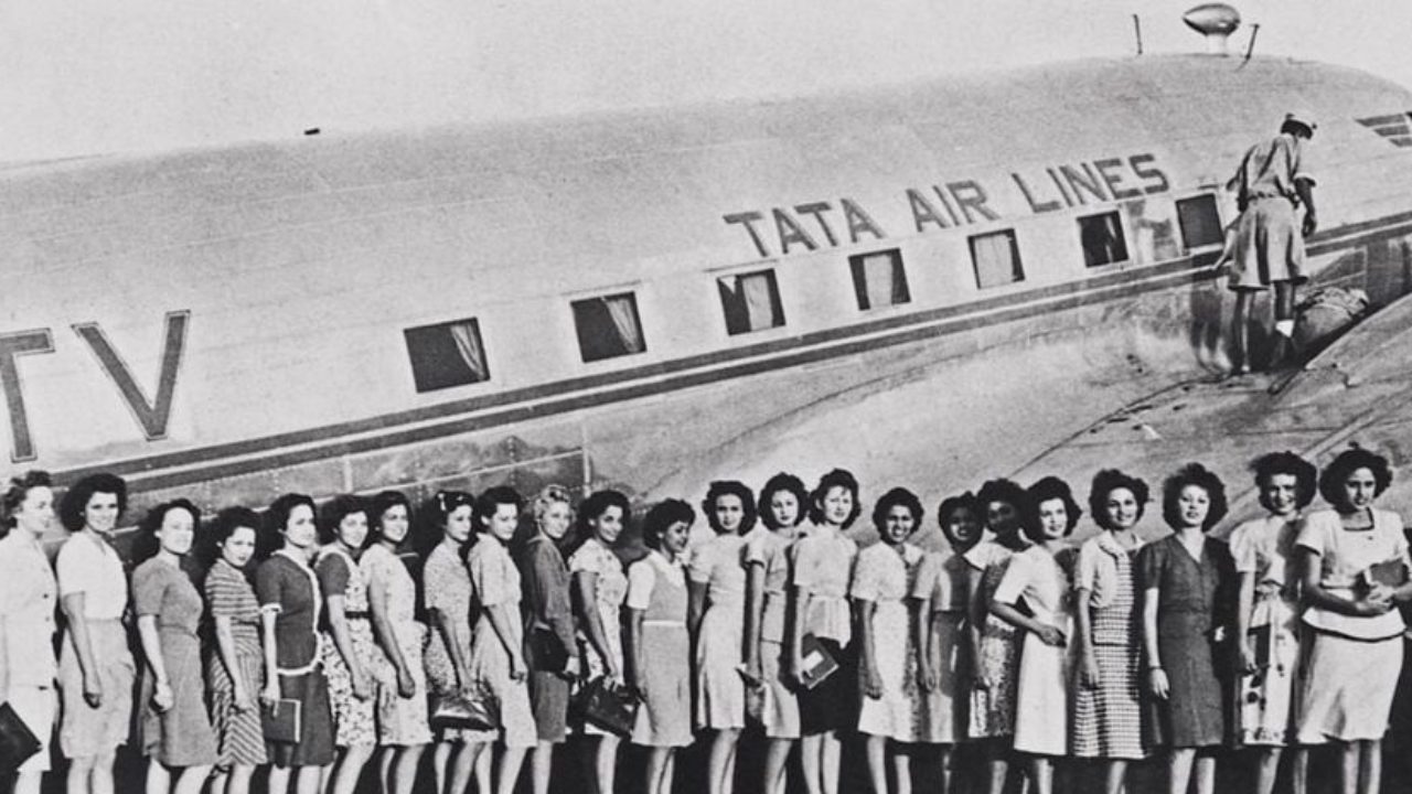 Black and white image of air hostesses standing in front of a Tata Air Lines aircraft